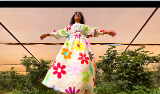 Liquid Retina ekranın renk aralığını ve çözünürlüğünü göstermek için MacBook Air ekranında renkli kıyafetli birinin fotoğrafı gösteriliyor