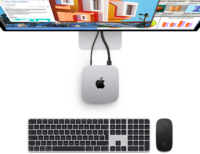 Yanında kablosuz Magic&nbsp;Keyboard ve Magic&nbsp;Mouse bulunan ve bir ekrana bağlı olan gümüş rengi Mac mini’nin, Apple logosuyla birlikte yukarıdan görünümü