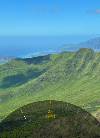 2 kat Telefoto özelliği kullanılıyor, ağaçlarla ve bitki örtüsüyle kaplı bir dağa yakınlaştırma yapılıyor