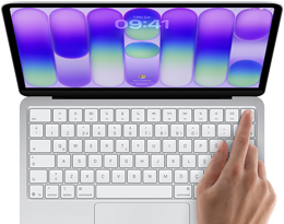 MacBook Neo, gümüş rengi, ekranda oturum açma penceresi gösteriliyor, kullanıcının parmağı klavyenin sağ üst köşesindeki Touch ID sensörüne dokunuyor