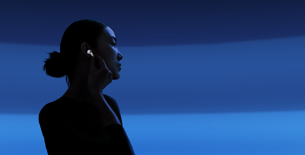 Dinleme modlarını değiştirmek için başparmağı ve işaret parmağıyla AirPods 5’i alt ucundan tutan bir kişi
