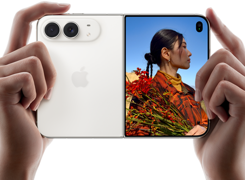 iPhone Duo, Yıldız Rengi, iki el tarafından açık ve yatay pozisyonda tutuluyor, sol panelde 48 MP Dual Fusion arka kameralar, sağ paneldeki dış ekranda fotoğrafı çekilen kişi gösteriliyor, bu kişi Duo Preview sayesinde fotoğrafı çekilirken kendi yüzünü görebiliyor