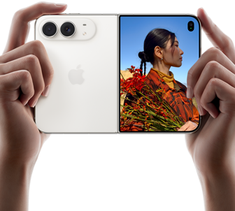 iPhone Duo, Yıldız Rengi, iki el tarafından açık ve yatay pozisyonda tutuluyor, sol panelde 48 MP Dual Fusion arka kameralar, sağ paneldeki dış ekranda fotoğrafı çekilen kişi gösteriliyor, bu kişi Duo Preview sayesinde fotoğrafı çekilirken kendi yüzünü görebiliyor